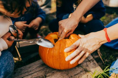Cadılar bayramı balkabağını balkabağı oyarak açık havada balkabağı oyan ellerinizi kapatın.