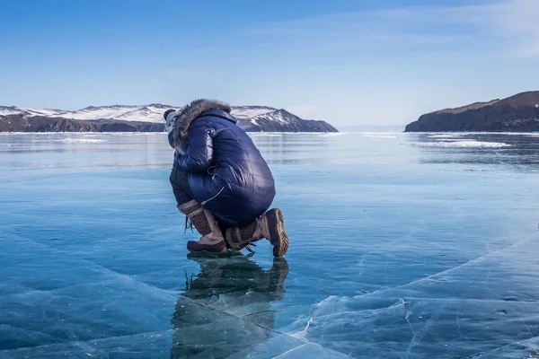 Femme assise sur le lac Baïkal gelé — Photo