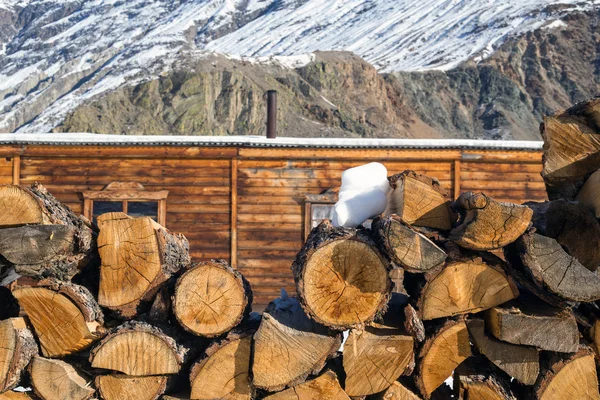 Stack of firewood at mountains background. Rural scene. — Stock Photo, Image