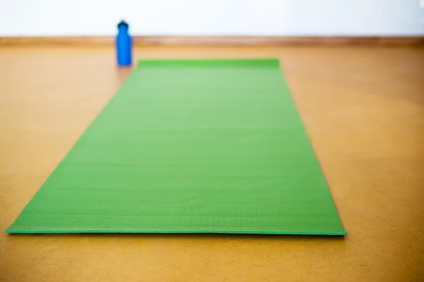 Sarı arka plan üzerinde Yoga mat, su şişesi. Yoga için donatım
