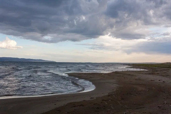 Синяя волна на песчаном пляже после шторма — стоковое фото
