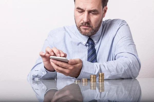 Homme mûr avec des pièces en euros empilées — Photo