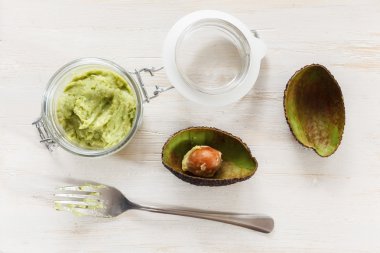 Avocado cream, preserving jar on chopping board clipart