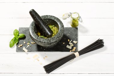 Pesto Genovese in mortar with ingredients and black spaghetti clipart