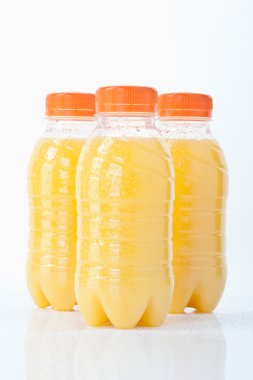 Portakal suyu şişeleri beyaz arka planda, yakın çekim