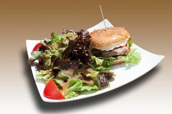 Burger with mixed salad in square plate — Stock Photo, Image