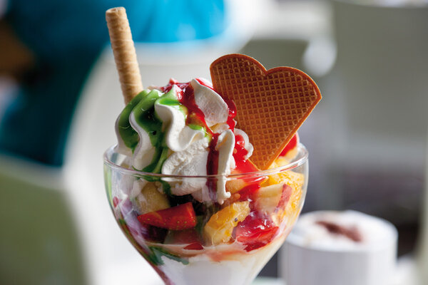 Close up of ice cream with whipped cream and heart shape waffle