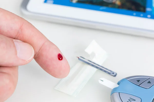 Hombre midiendo azúcar en sangre con glucómetro — Foto de Stock