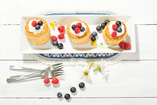 Pasteles de hojaldre con helado de vainilla y crema, arándanos y r —  Fotos de Stock