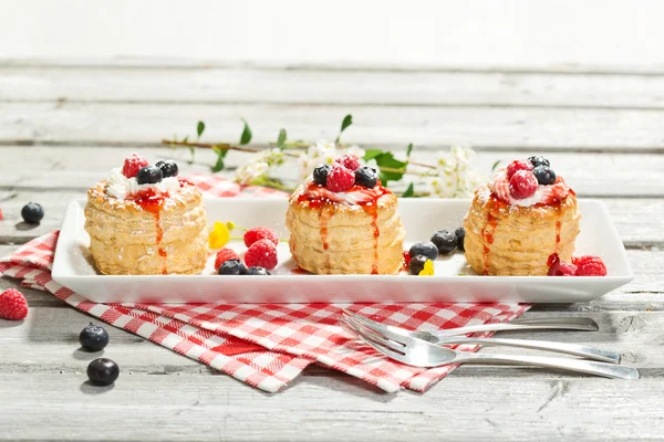 Pasteles de hojaldre con helado de vainilla y crema, arándanos y r —  Fotos de Stock