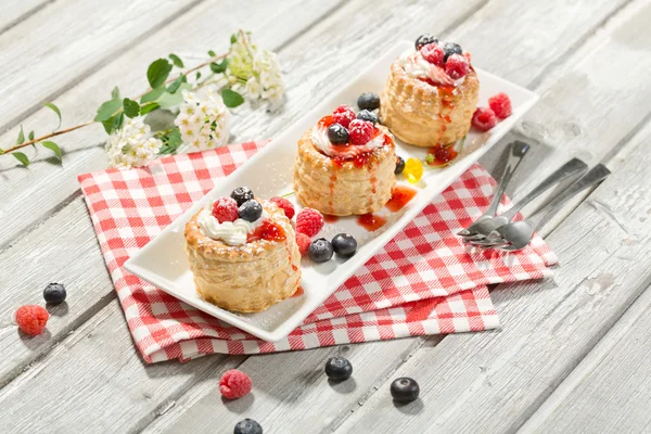 Puff pastries with vanilla-icecream and cream, blueberries and r — Stock Photo, Image
