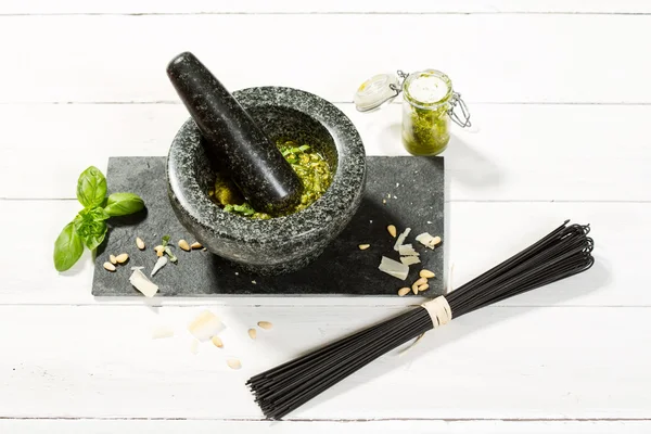 Pesto Genovese mozsárban összetevők és fekete spagetti — Stock Fotó