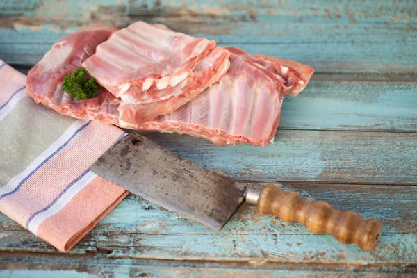 Close up de costelas sobressalentes de porco com cutelo de carne — Fotografia de Stock