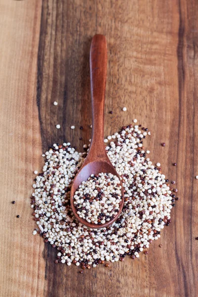 Tricolor quinoa in wooden bowl, wooden spoon — Stock Photo, Image