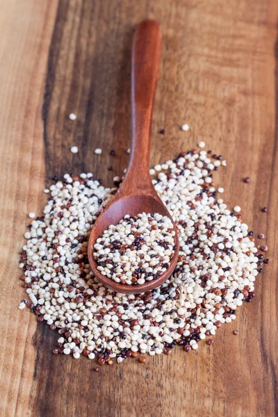 Tricolor quinoa in wooden bowl, wooden spoon — Stock Photo, Image