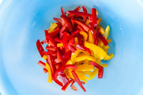 Gele en rode paprika in blauwe kom — Stockfoto