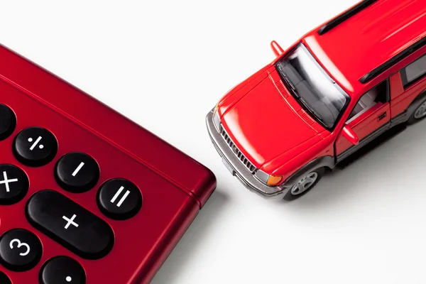 Калькулятор и игрушечный автомобиль на белом фоне — стоковое фото