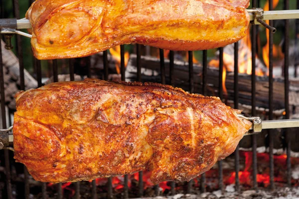 Varkensrollade met krakende roosteren op houtskool grill — Stockfoto