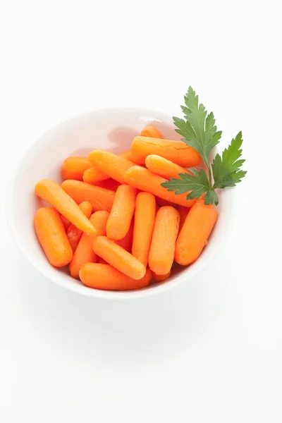 Baby carrot in bowl on white background — Stock Photo, Image