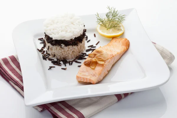 Salmón y tarta de arroz adornado con eneldo, rodaja de limón, ajo en p —  Fotos de Stock