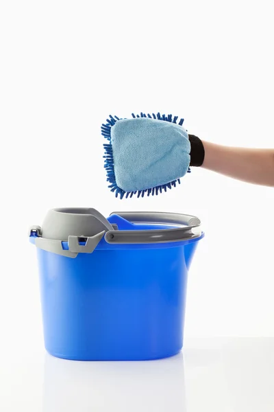 Human hand with glove and bucket on white background — Stock Photo, Image