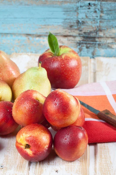 Close-up van nectarines, appels en peren met servet en mes — Stockfoto