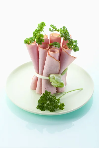 Close up of Leberkaese slices rolled up,tied and garnished with — Stock Photo, Image