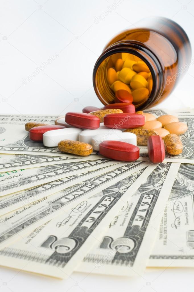 Prescription bottle and pills on US banknotes,close-up