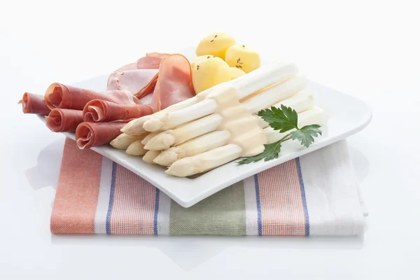 Asparagus,potatoes,parma ham and parsley in plate on napkin — Stock Photo, Image