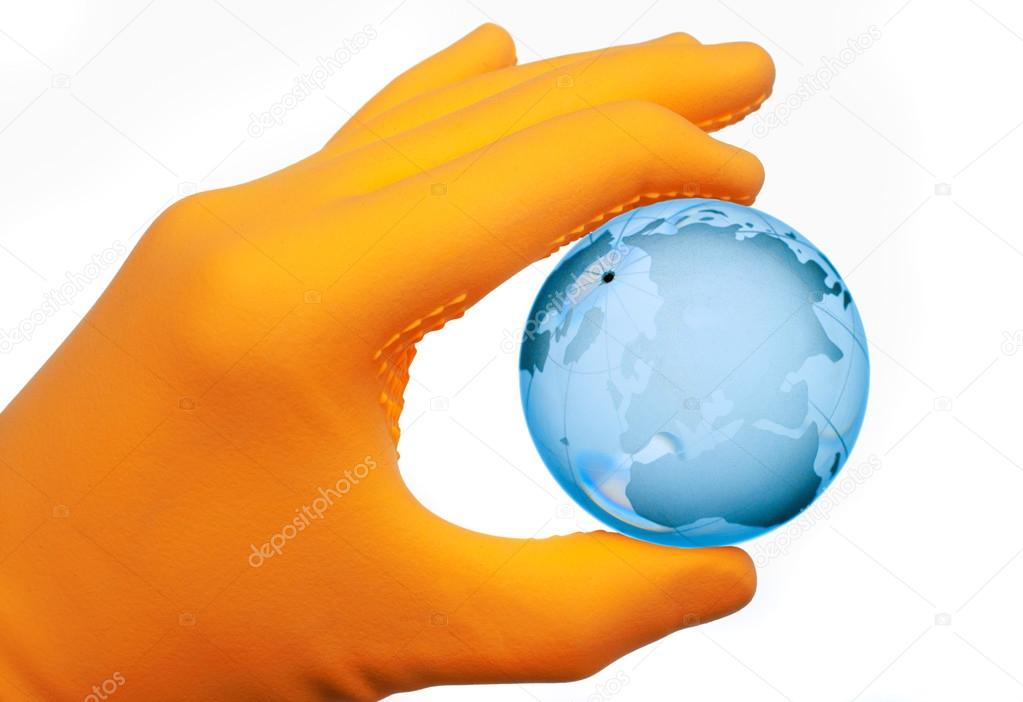 Human hand with rubber glove holding glass globe against white b