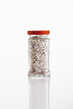 Beyaz arka plan üzerinde cam kavanoza arpacık