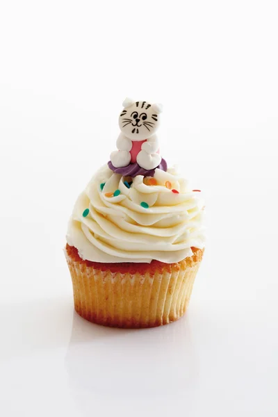 Close up de manteiga de baunilha cupcake com gato figurine agains — Fotografia de Stock