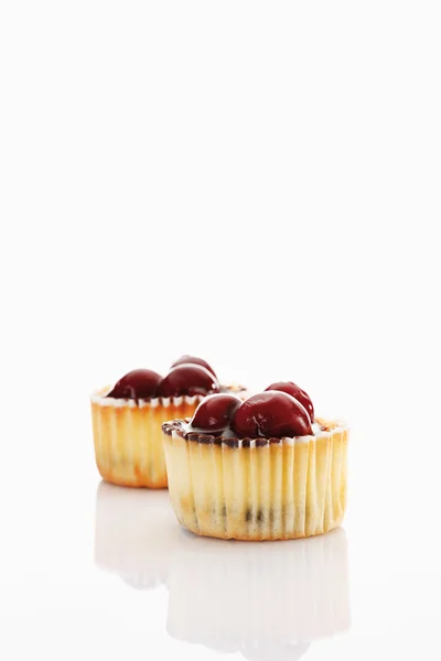 Close up of cupcake topped with chocolate cream and cherries aga — Stock Photo, Image