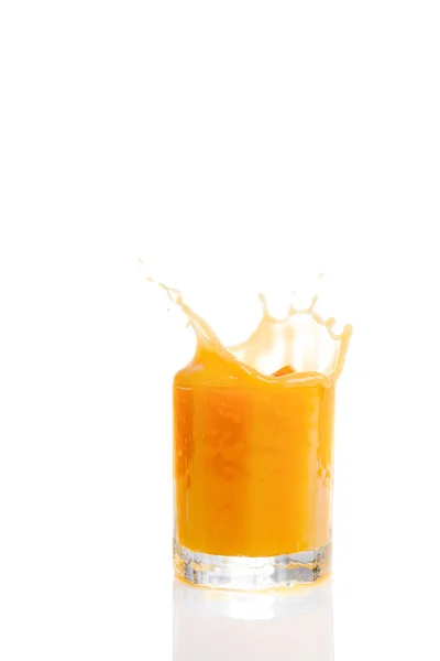 Spritzender Orangensaft vor weißem Hintergrund — Stockfoto