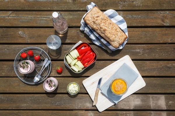 Picnic con pan integral de trigo espelta, salsas, cruditos, fresa —  Fotos de Stock