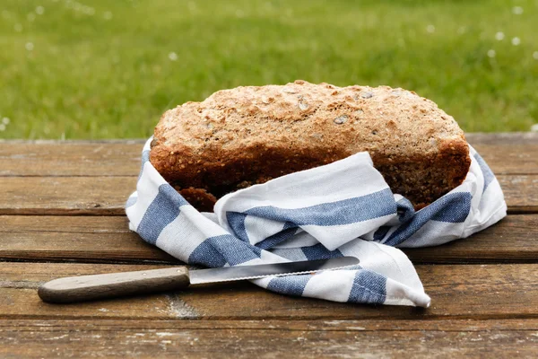 Pão integral de trigo soletrado sobre mesa de madeira — Fotografia de Stock