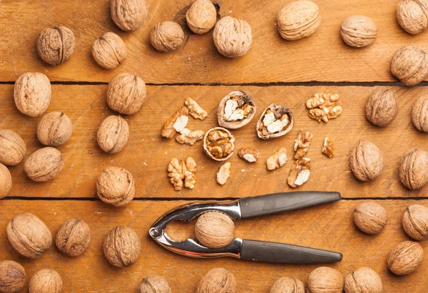 Nueces y cascanueces sobre madera — Foto de Stock