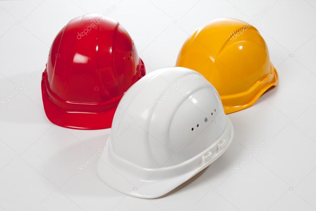 Red yellow white hardhats on white background