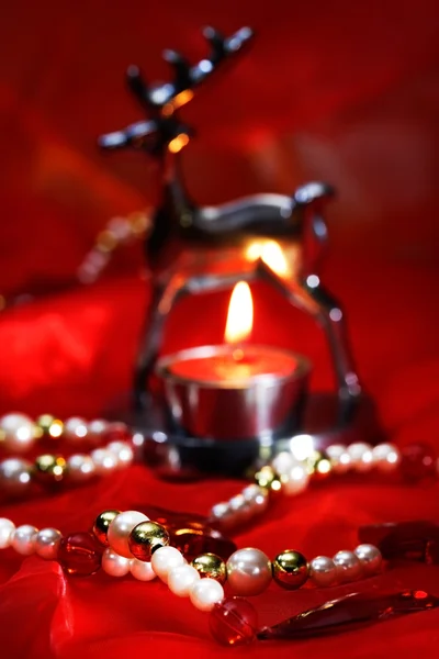 Decoración de Navidad con luz de té ardiente y perlas en rojo — Foto de Stock