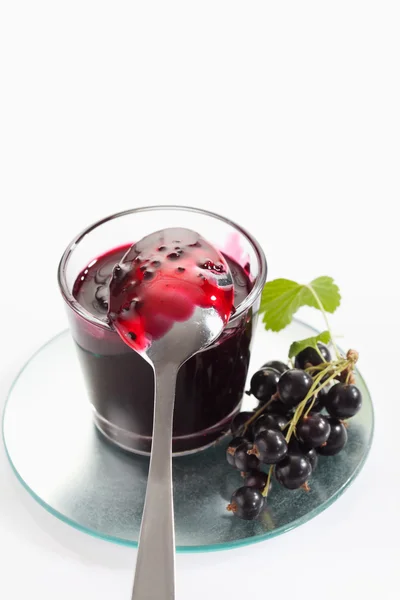 Black currant jam in glass, spoon and black currants — Stock Photo, Image