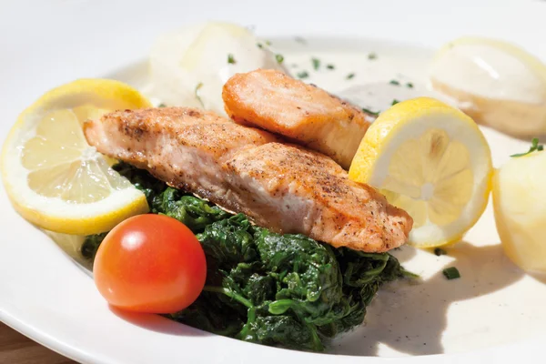 Nahaufnahme von gebratenem Lachs mit Spinat, Salzkartoffeln und Sahne — Stockfoto