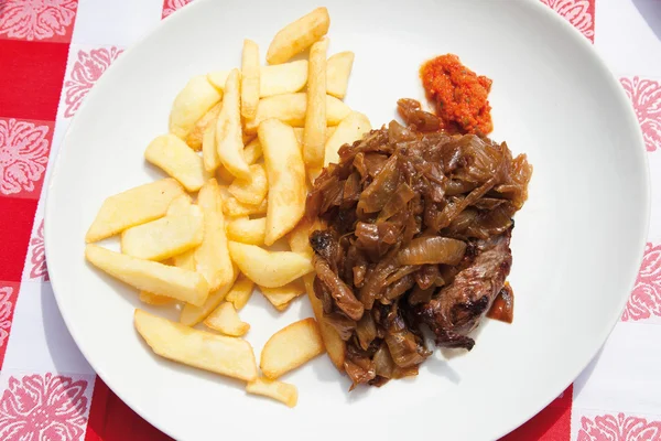 Close up of beef steak with fried onions and french fries — Stock Photo, Image