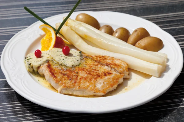 Nahaufnahme von Putensteak mit Spargel, Kräuterbutter und Kartoffeln — Stockfoto