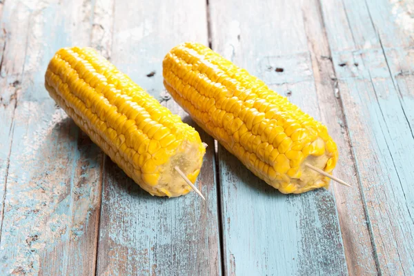 Zamknij się z kolby kukurydzy skewered na drewnianym stole — Zdjęcie stockowe