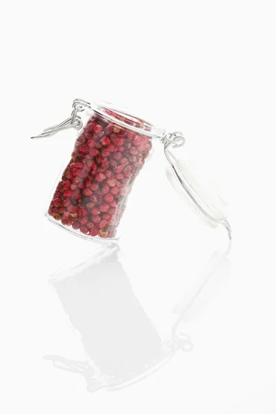 Сухий червоний перець у скляній банці на білому тлі — стокове фото