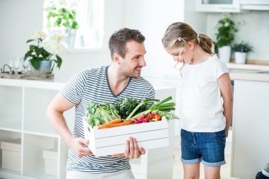 Baba ve kızı mutfakta sebze kutusu