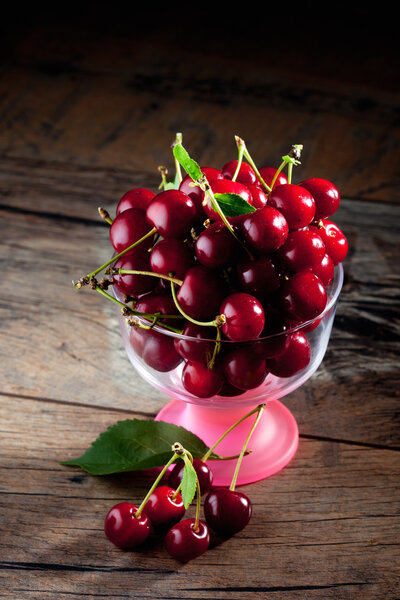 Sour cherries in bowl, on wood