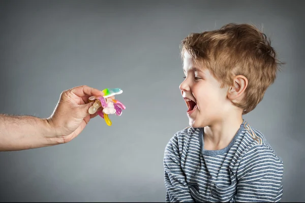 Porträt eines Jungen, wie Süßigkeiten, grauer Hintergrund — Stockfoto