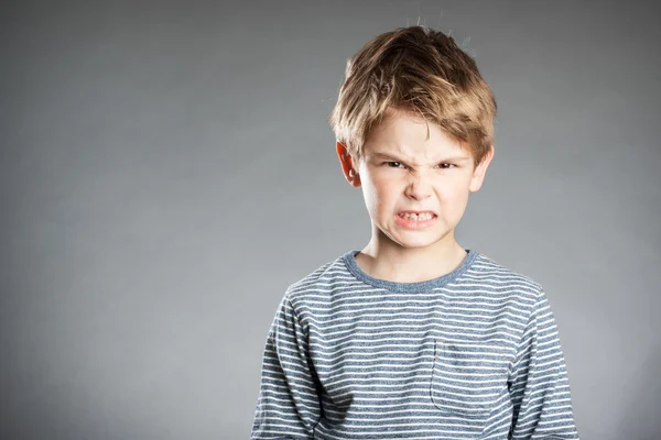 Портрет мальчика, эмоции, сердитый, серый фон — стоковое фото