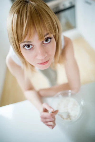 Молодая блондинка ест мюсли на кухне — стоковое фото